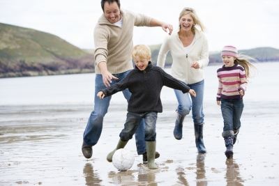 Family Playing Soccer on the Beach